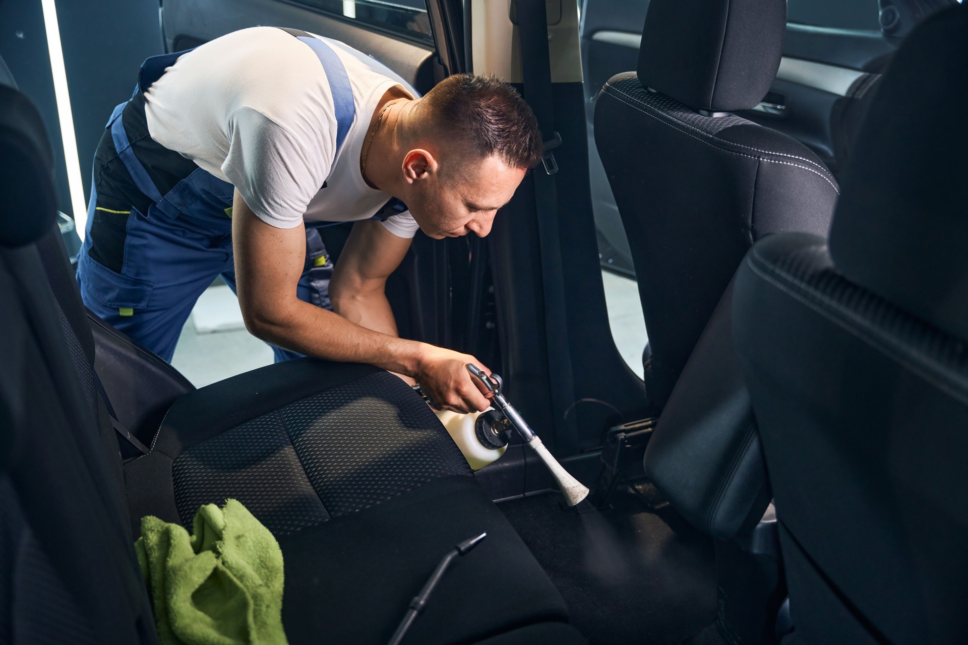 Un travailleur nettoie à fond l’intérieur d’une voiture avec un tornador